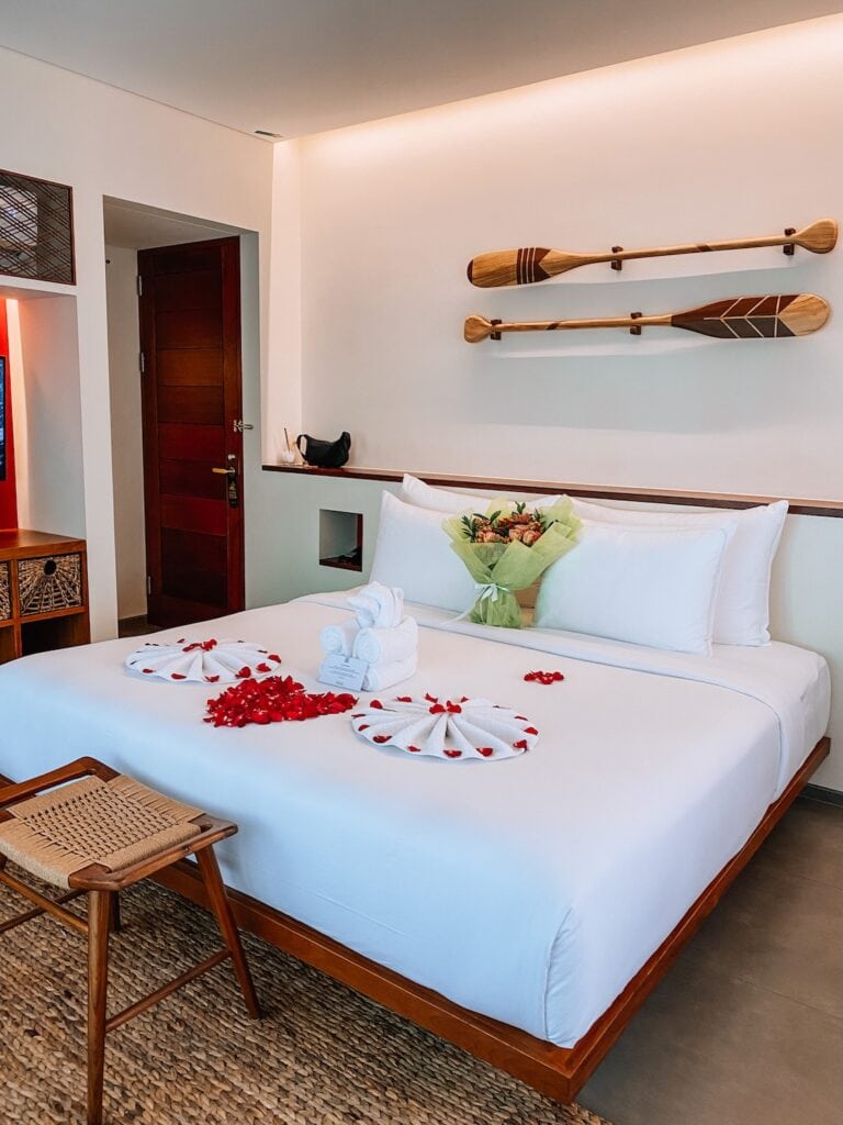 Cozy hotel room with traditional Balinese decor in Canggu or Seminyak, featuring a comfortable bed a.