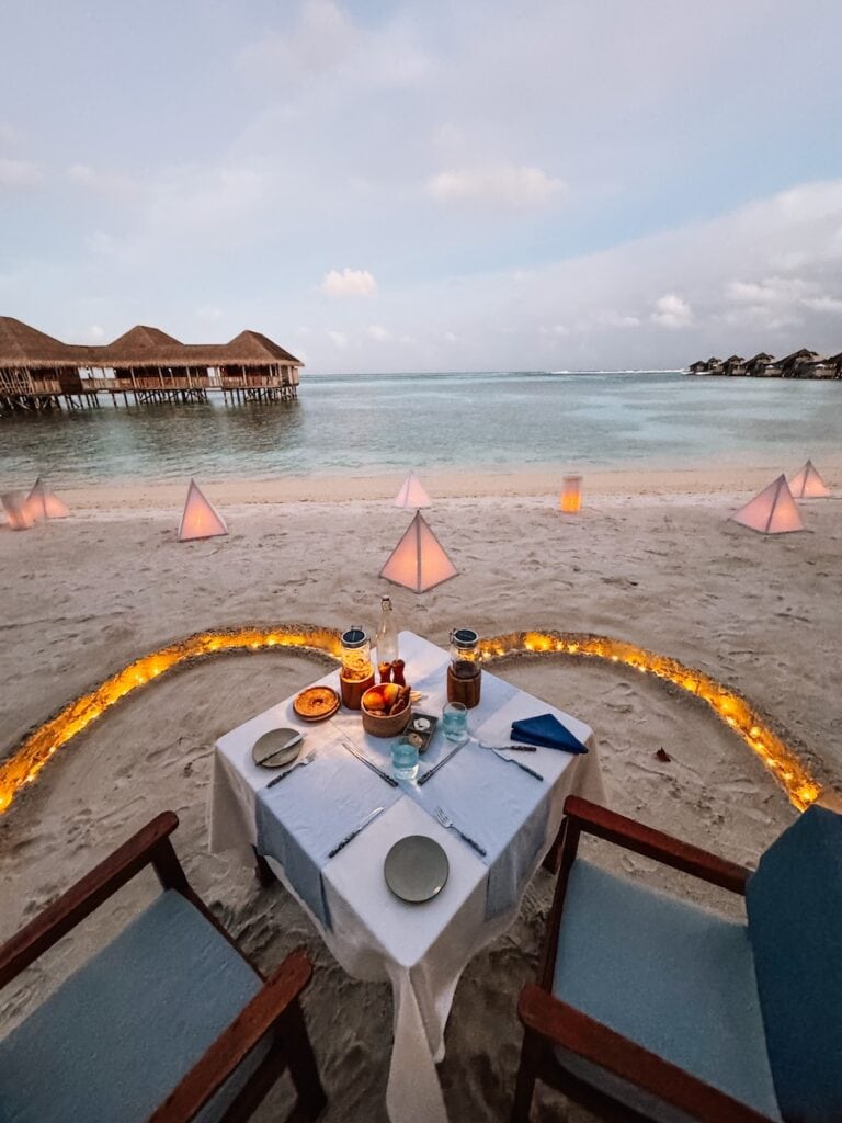 Private dinner setup with lanterns on the beach Maldives