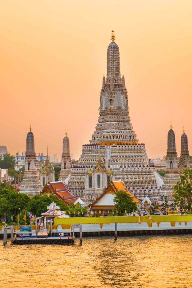 Intricate temple in Bangkok at sunset, showcasing Thai architecture and cultural heritage.