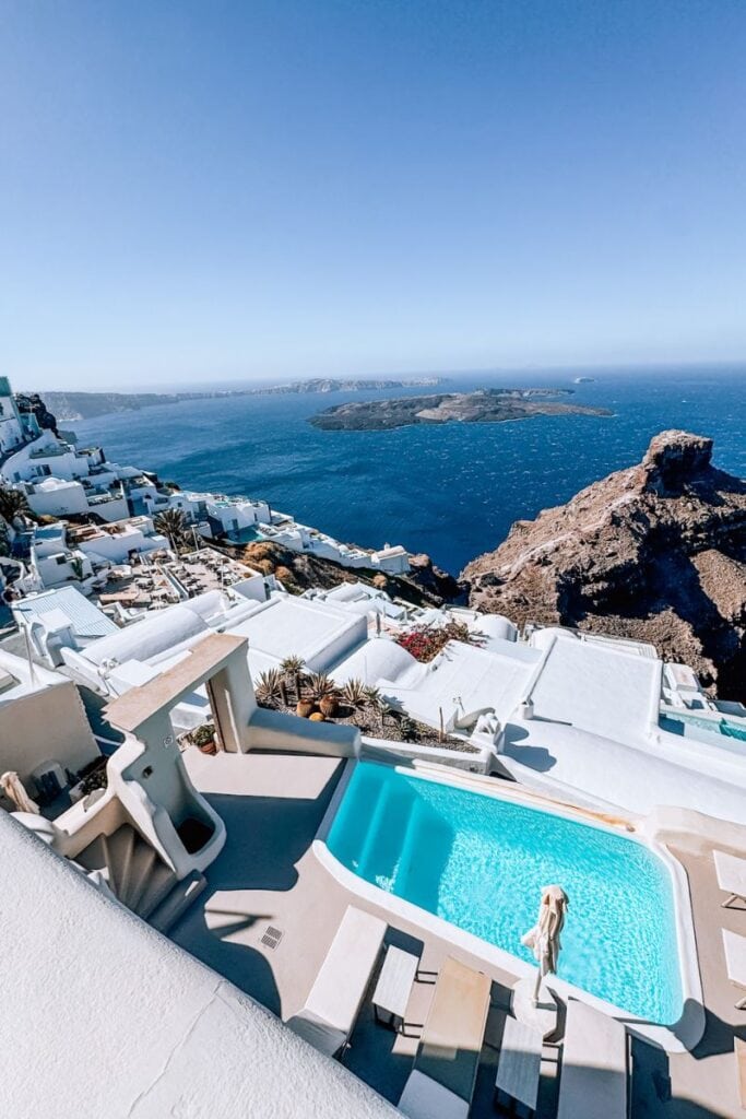 Breathtaking view of Santorini’s white buildings and blue sea from a luxury hotel balcony. Ideal for a romantic stay.