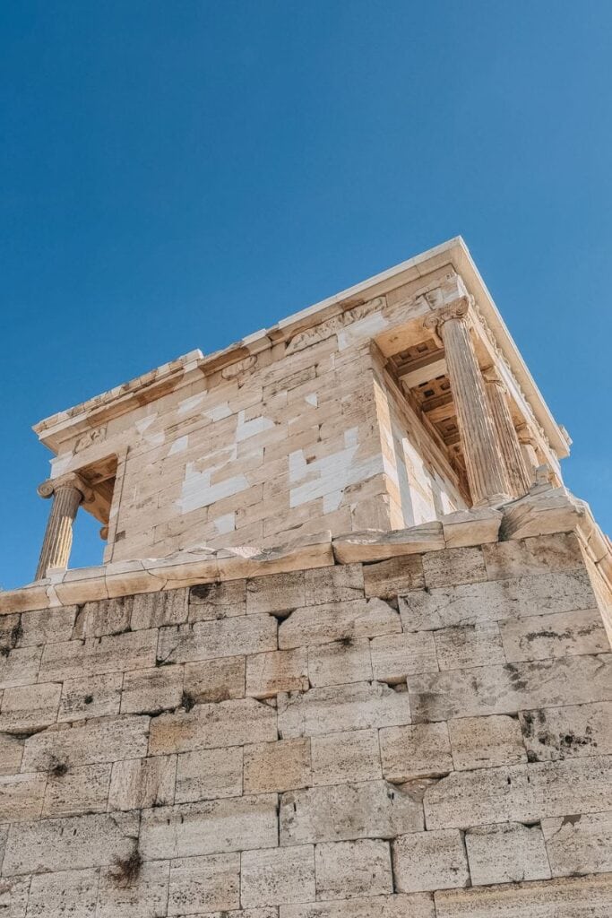 Ancient Greek temple ruins with classical columns against a clear blue sky.
