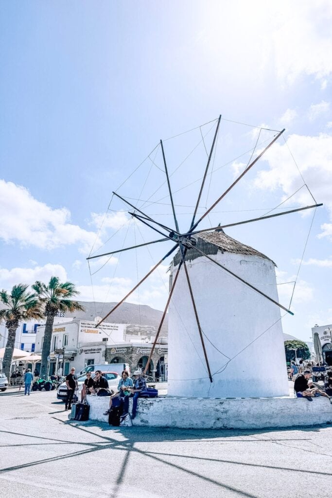 Windmill in Mykonos, Greece, popular tourist spot with clear skies and local visitors.