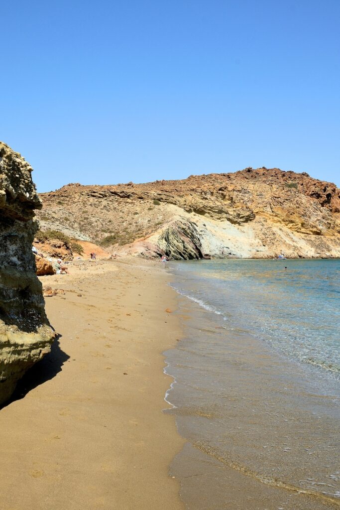 Quiet beach in Paros with golden sand and clear blue waters.