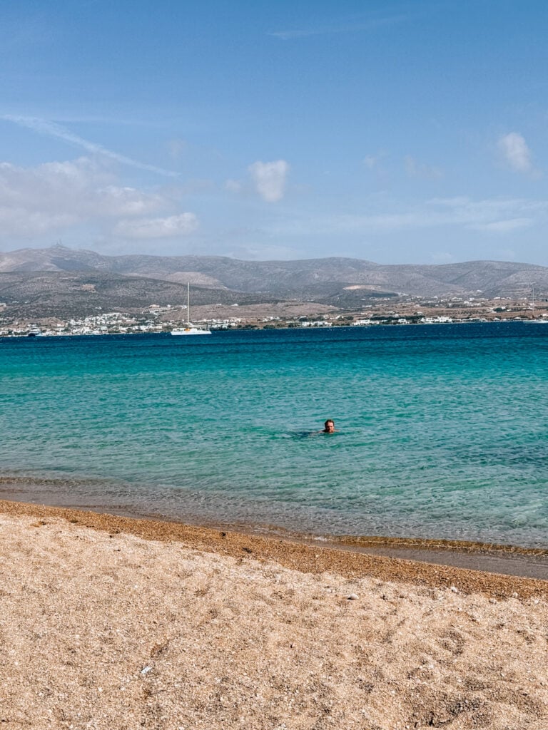 ギリシャ、パロスビーチの穏やかなターコイズブルーの海で泳ぐ男性。