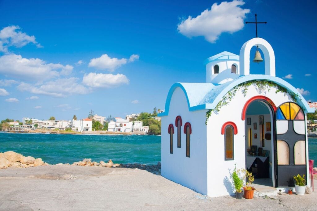 Charming white and blue Greek chapel by the sea on a sunny day.