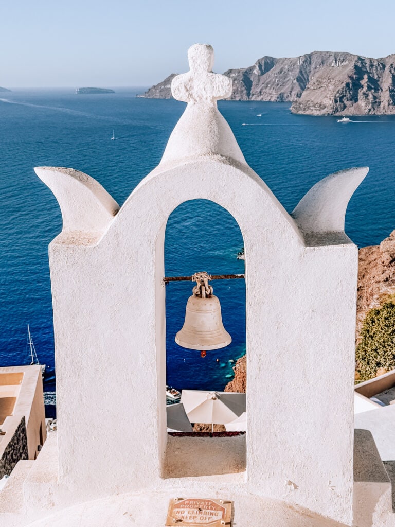 Traditional Greek bell tower overlooking the Aegean Sea in Santorini.